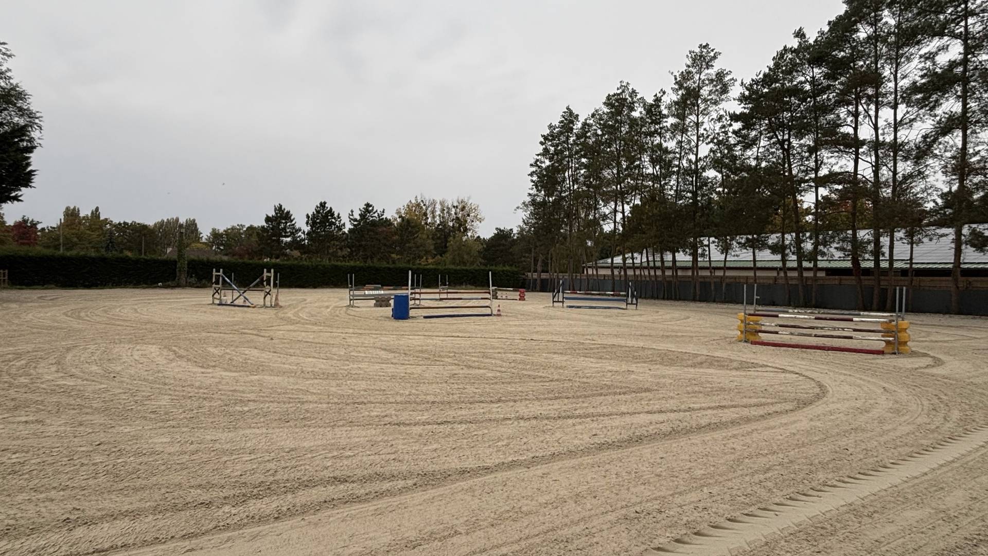 Grande carrière en sable avec son parc d’obstacles, entourée de pins, à Gambais